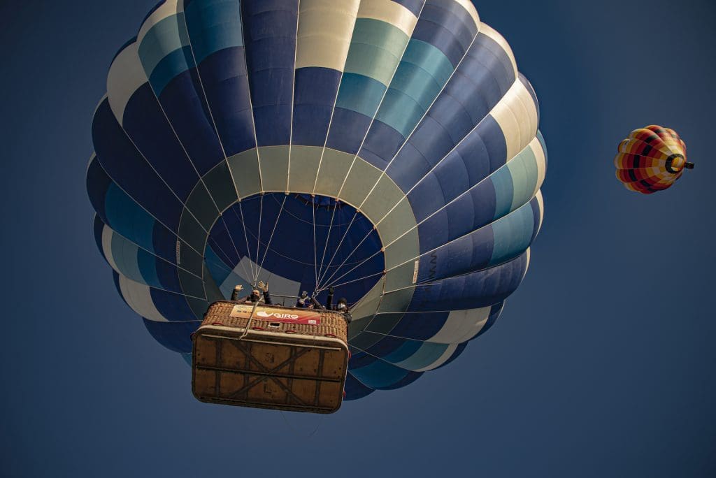 due mongolfiere in volo con persone sorridenti